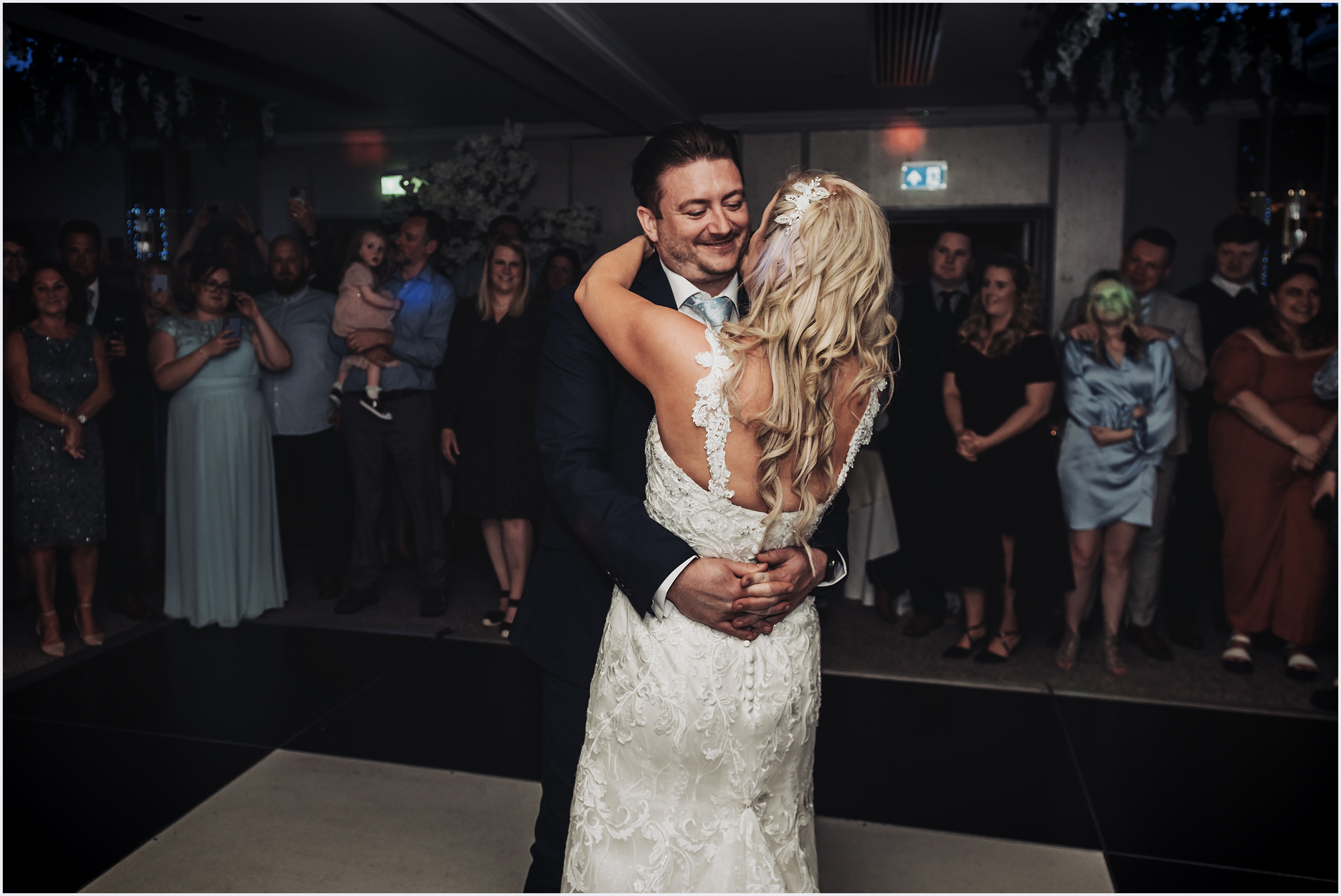 A groom holding his wife close with his arms around her waist during their first dance at The Grosvenor Pulford Hotel and Spa.