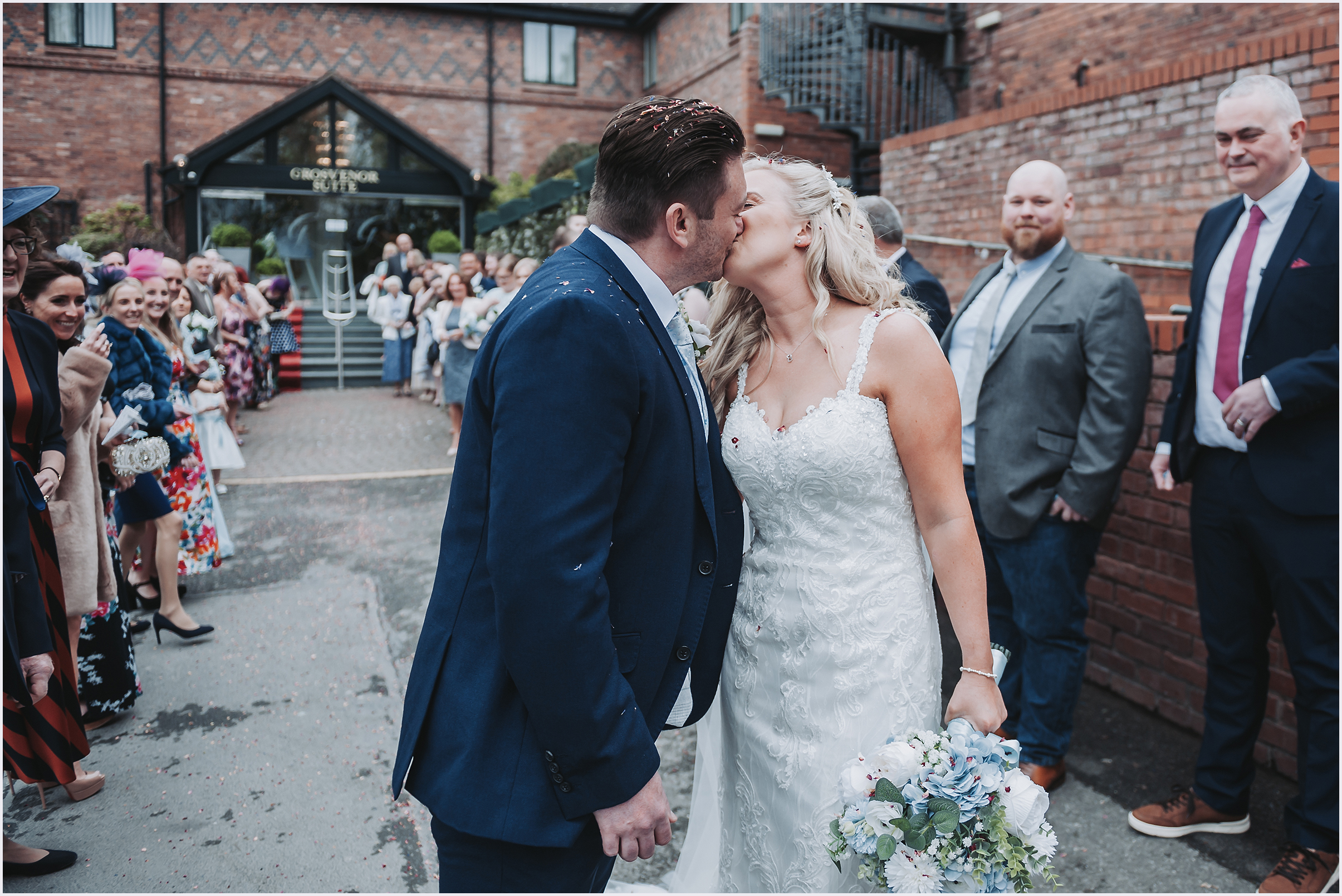 A couple kiss after their confetti shot at The Grosvenor Pulford Hotel and Spa.