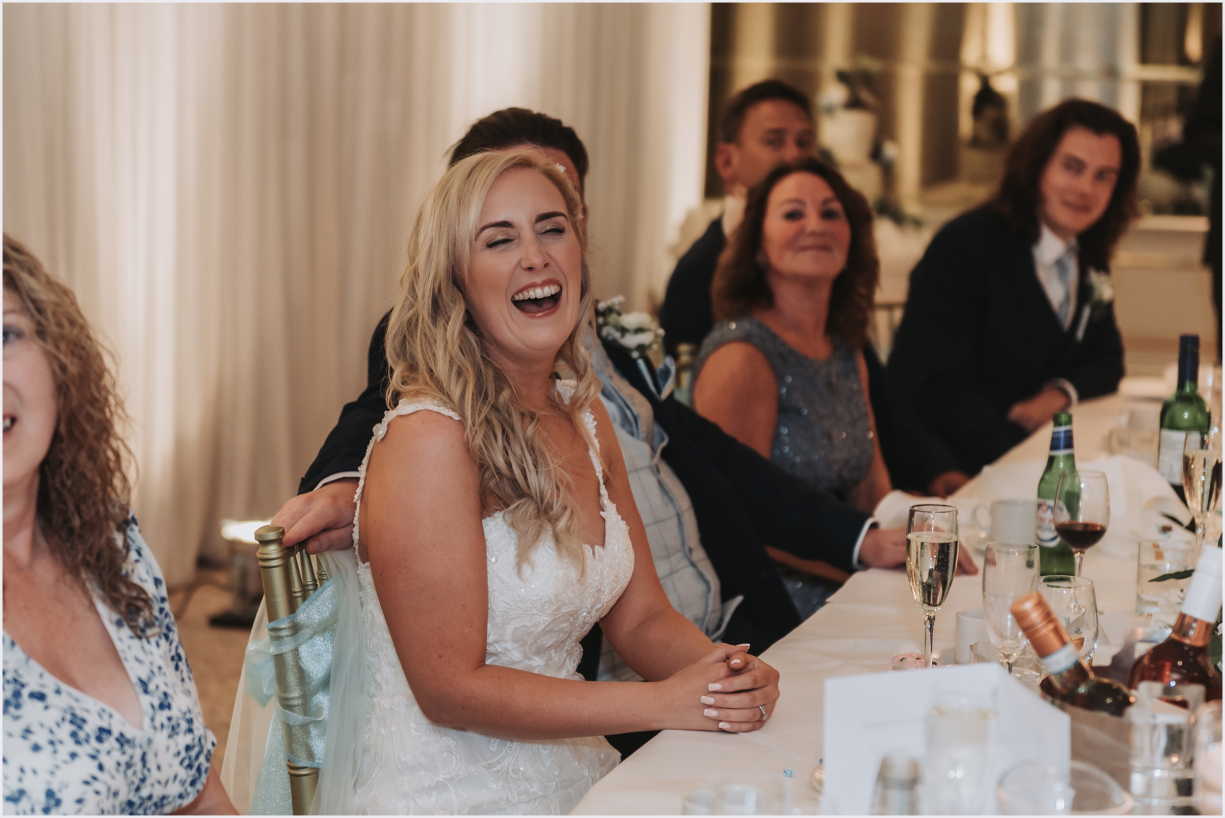A bride laughing out loud as the speeches are said.  Image captured by North Wales wedding Photographer Helena Jayne Photography