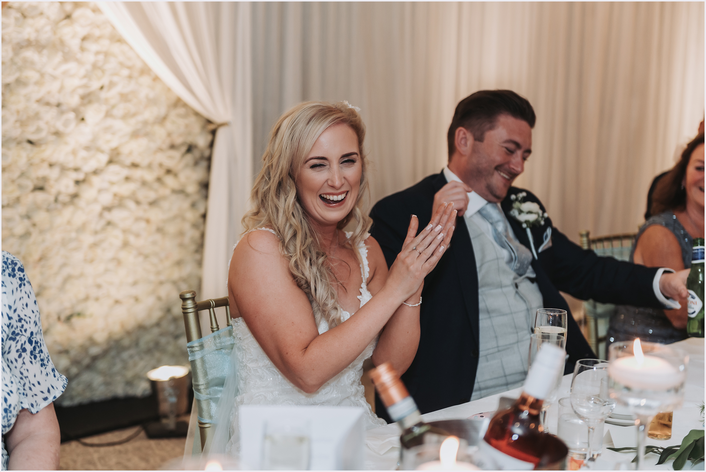 A bride clapping and laughing during the speeches at The Grosvenor Pulford Hotel and Spa.