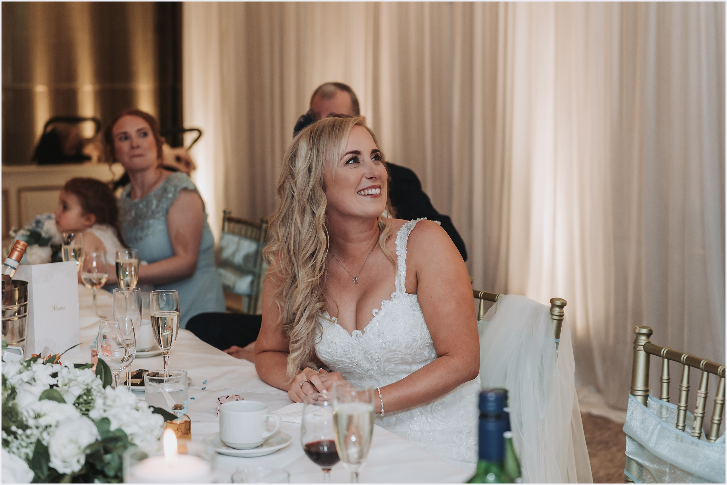 A bride looking up beaming with happiness at her new husband during the speeches at The Grosvenor Pulford Hotel and Spa.