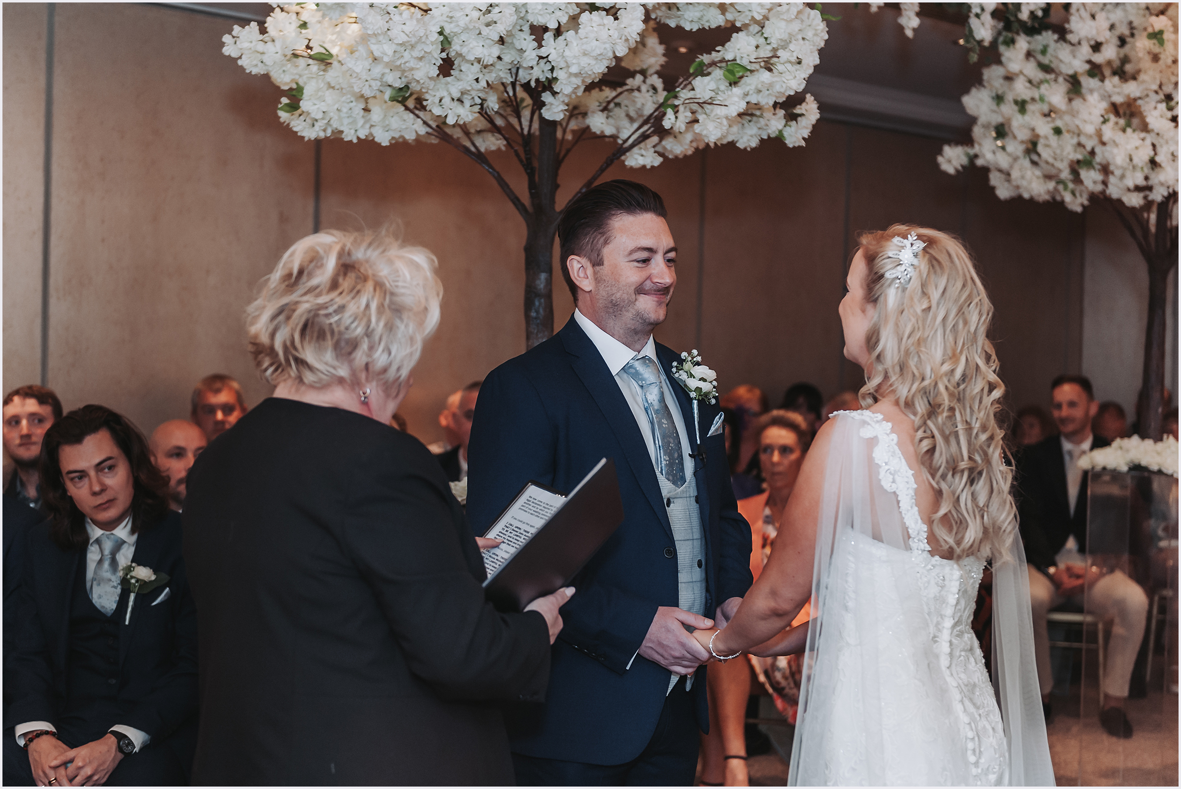 A groom smiling and his beautiful bride and they exchange vows during their wedding ceremony at The Grosvenor Pulford Hotel and Spa