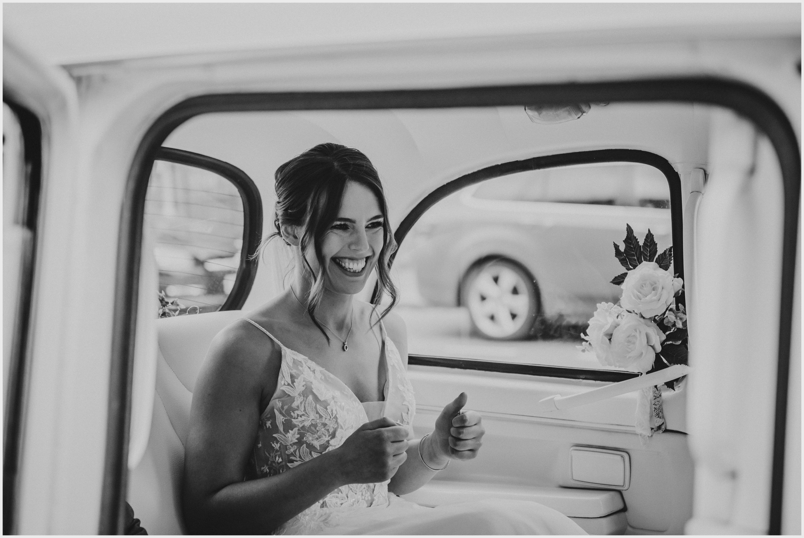 A beautiful, smiling bride sitting in the white cab that has brought her to the church to be married.  Image captured by Helena Jayne Photography Chester wedding photographer