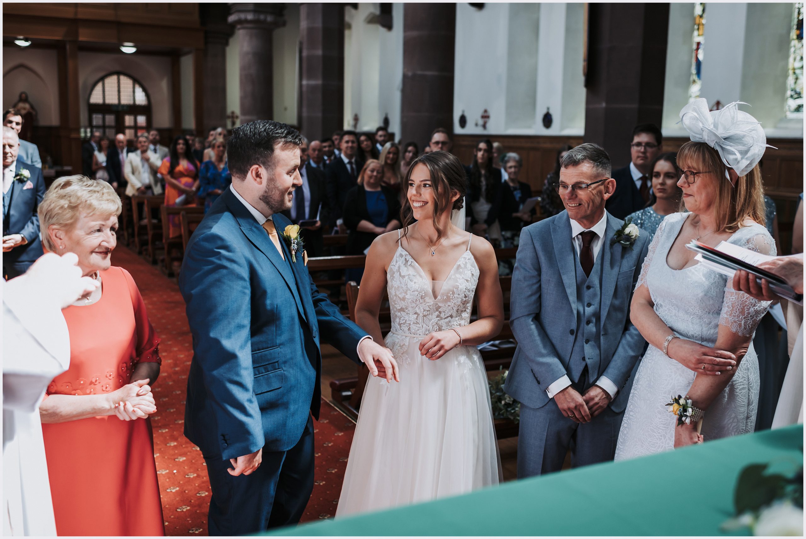 A beautiful bride and groom look into each other's eyes while holding hands during their church wedding ceremony in Chester.  Image taken by North Wales Wedding Photographer Helena Jayne Photography 