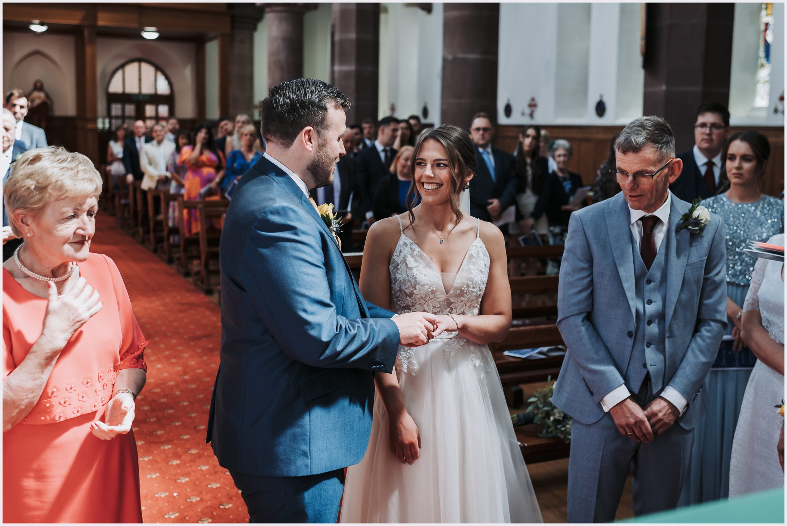 A groom places the wedding ring onto his wife's finger during their church wedding ceremony.  Image captured by Helena Jayne Photography a wedding photographer based in Chester