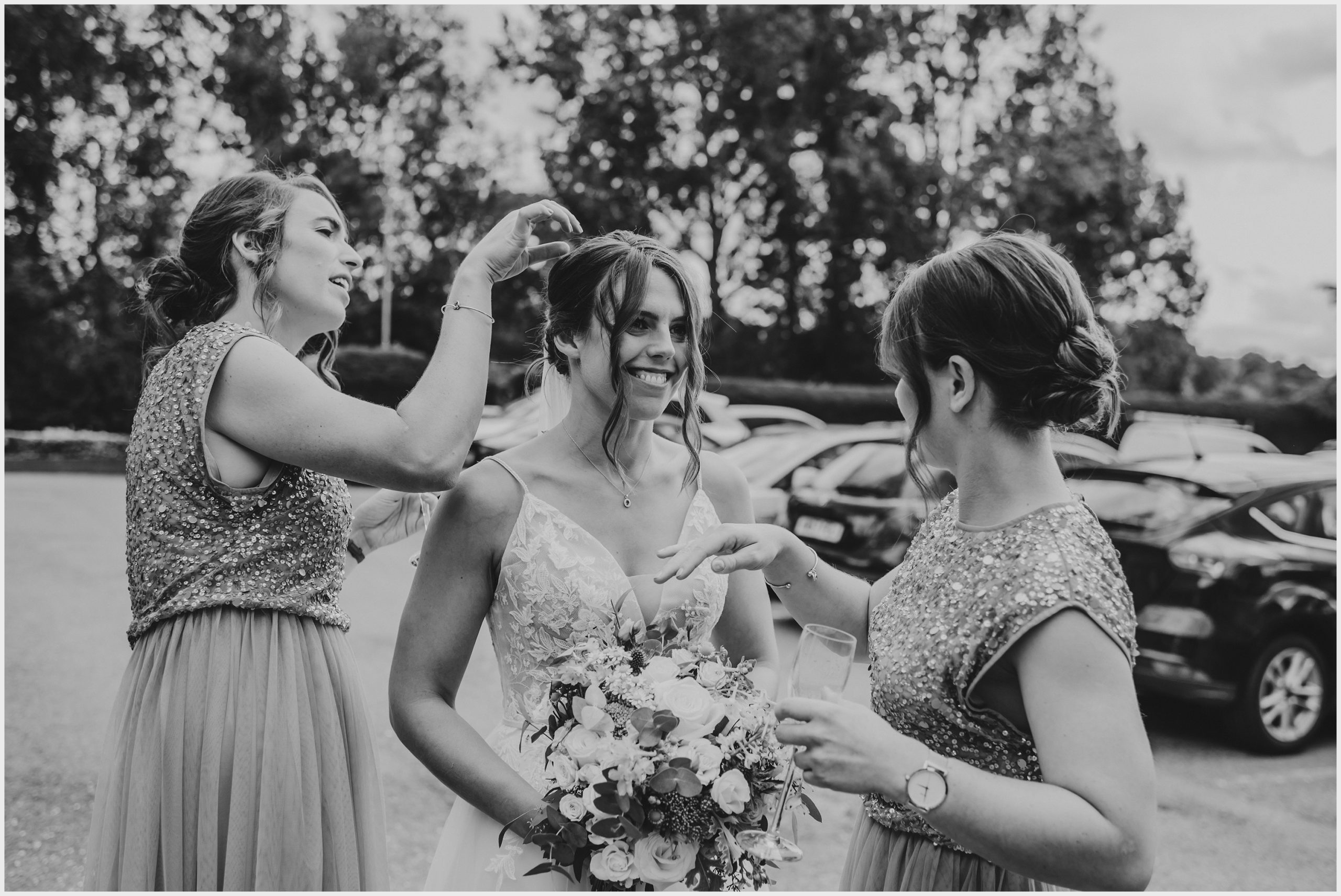 A bride with her head thrown back laughs as her bridesmaids remove confetti from her hair.  Image captured by Grosvenor Pulford Hotel and Spa wedding photographer Helena Jayne Photography