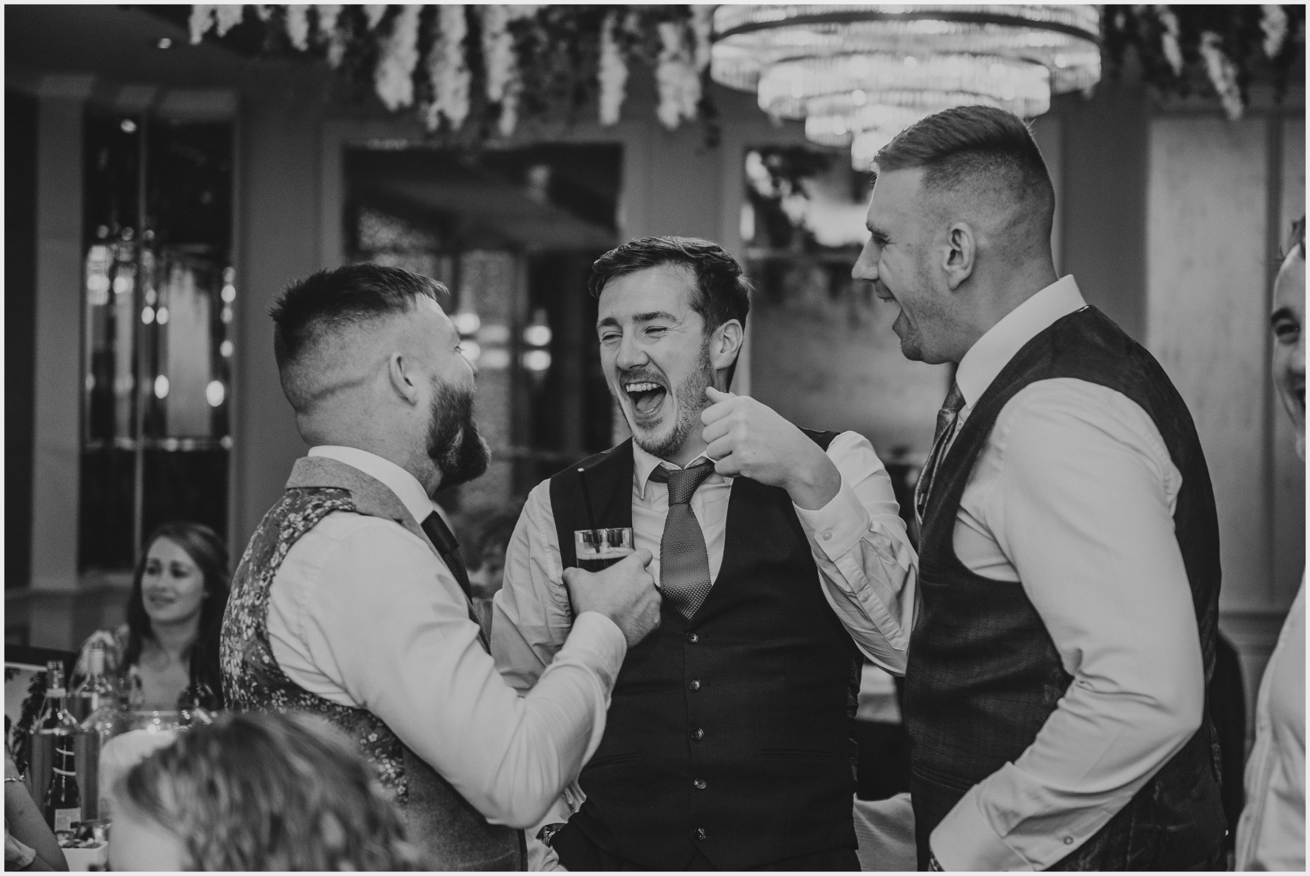 Guests joke and laugh during the wedding reception at The Grosvenor Pulford Hotel and Spa.  Image taken by Chester based wedding photographer Helena Jayne Photography