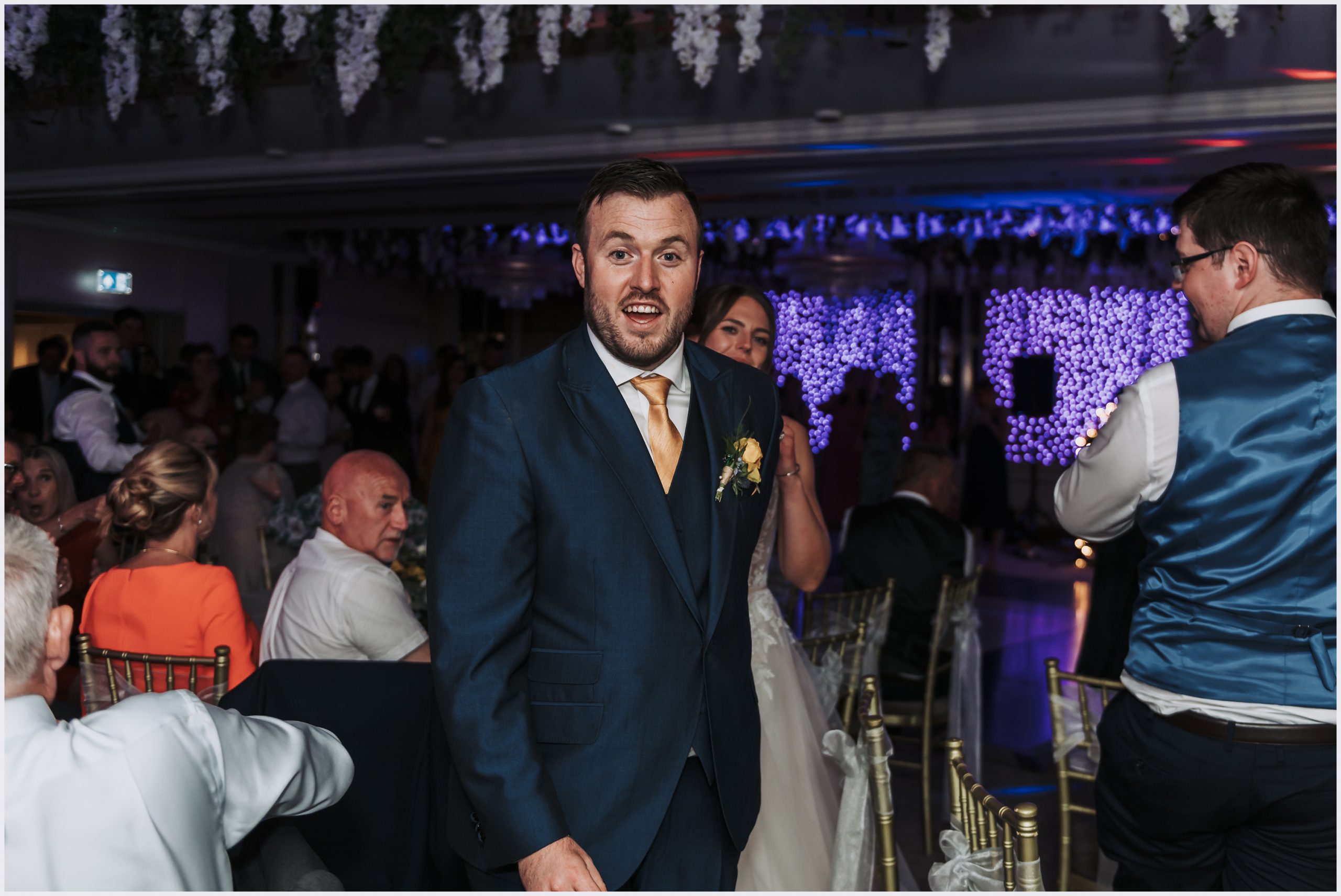 A groom beams at the camera as he leads his wife to the dance floor to dance thier first dance at The Grosvenor Pulford Hotel and Spa.  Image captured by Helena Jayne Photography a Chester based wedding photographer