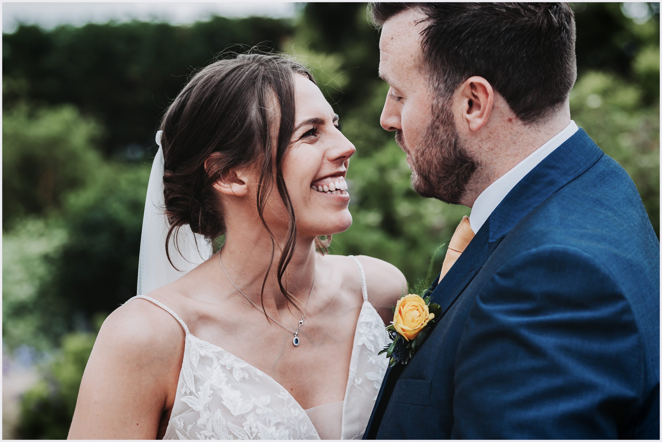 A bride smiles and stares into her husband's eyes during their bride and groom photoshoot.  Image captured by Helena Jayne Photography a wedding photographer based in north Wales
