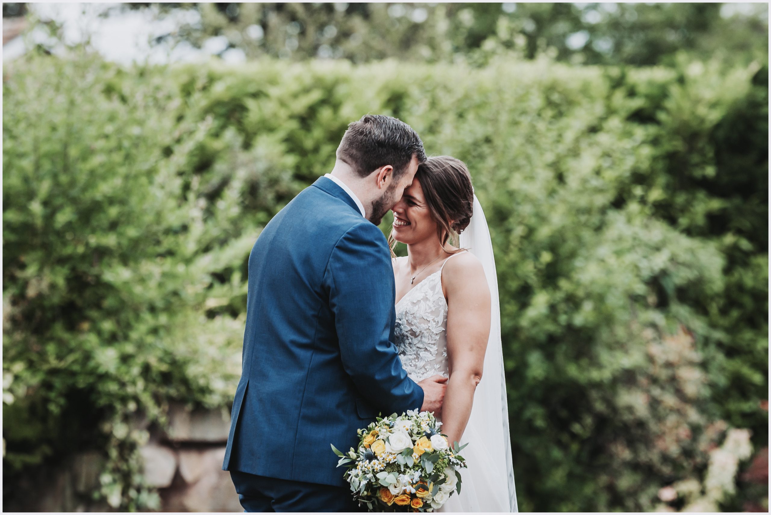 A gorgeous bride smiles at her husband during their bride and groom photoshoot at The Grosvenor Pulford Hotel and Spa.  Image captured by Chester wedding photographer Helena Jayne Photography a Chester based wedding photographer