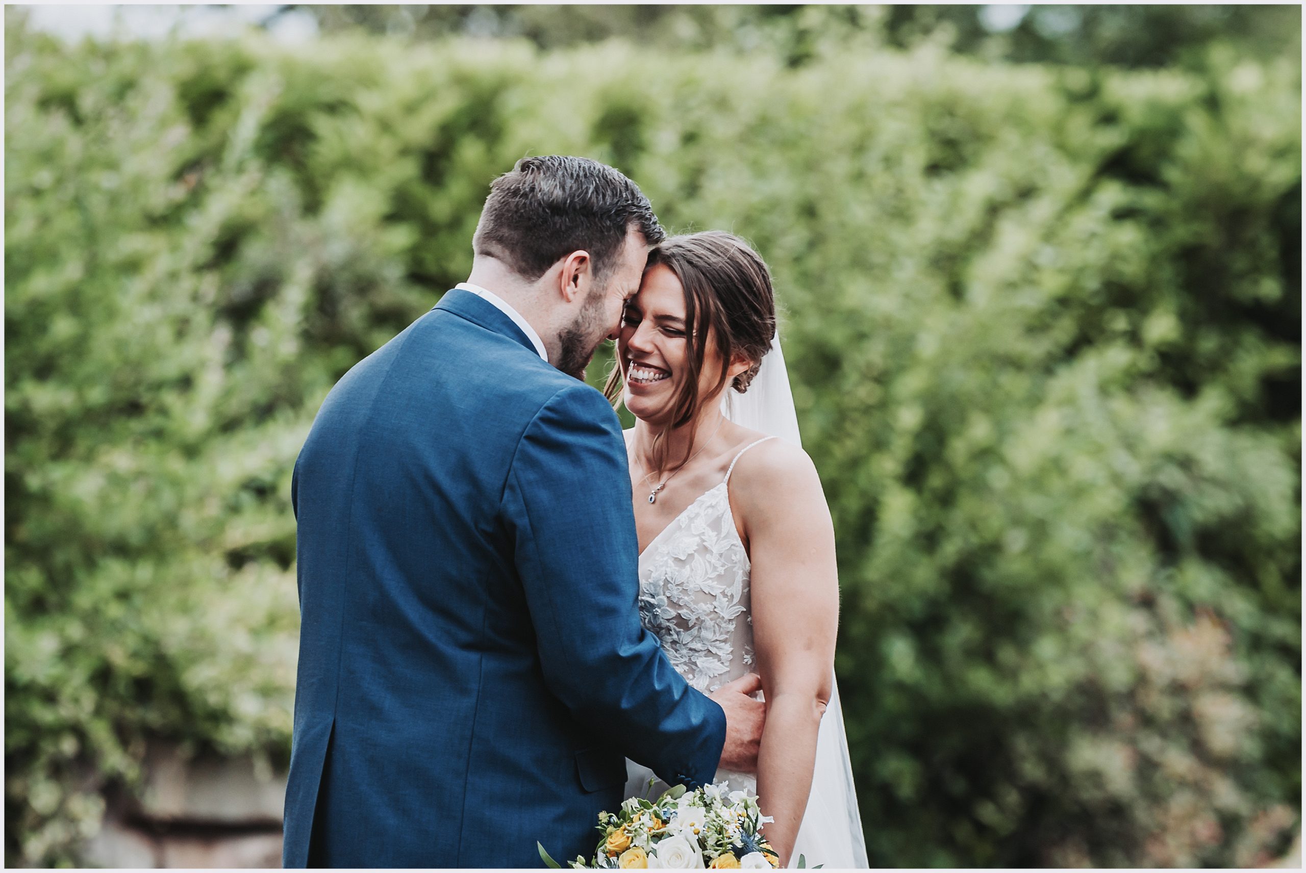 A gorgeous bride smiles at her husband during their bride and groom photoshoot at The Grosvenor Pulford Hotel and Spa.  Image captured by Chester wedding photographer Helena Jayne Photography a Chester based wedding photographer