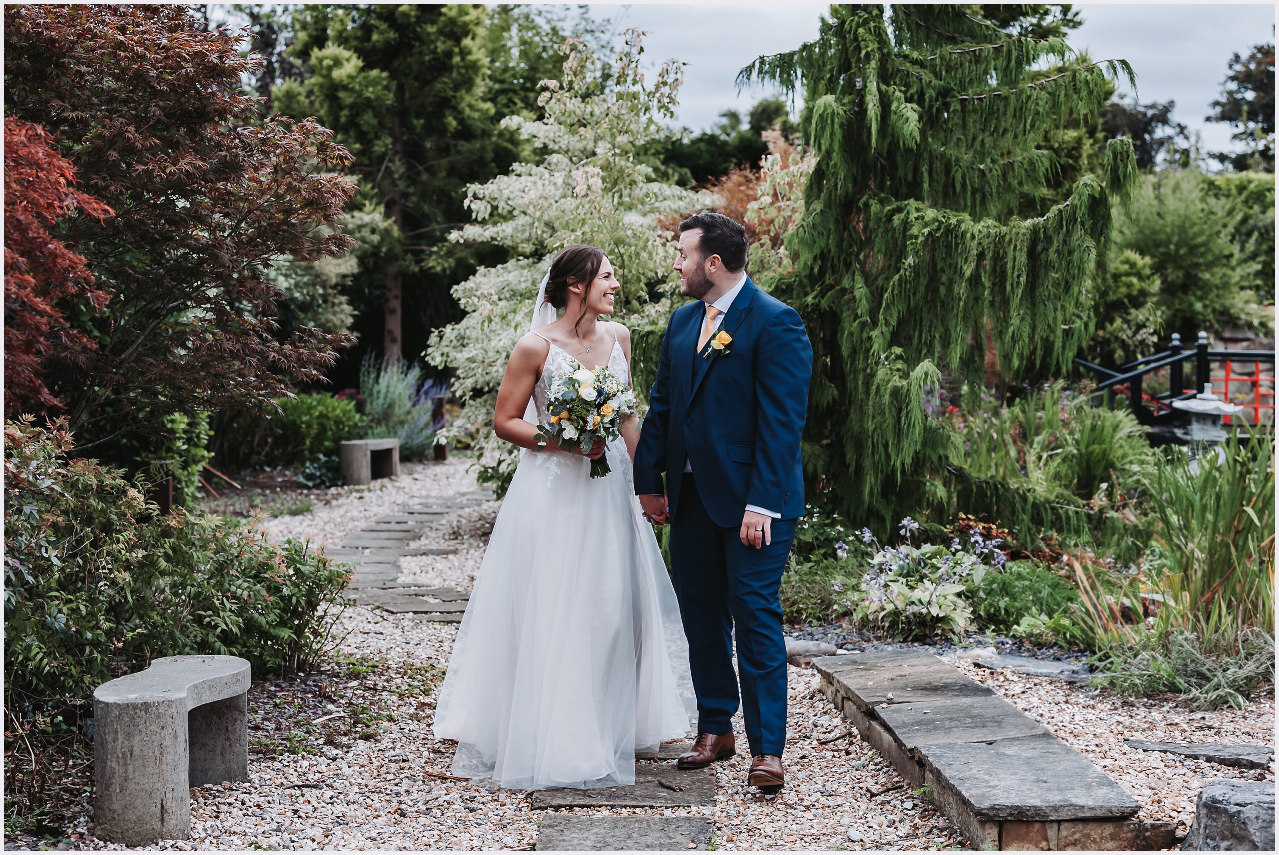 A gorgeous bride and groom smile and look into each other's eyes in the beautiful Asian gardens at The Grosvenor Pulford Hotel and Spa