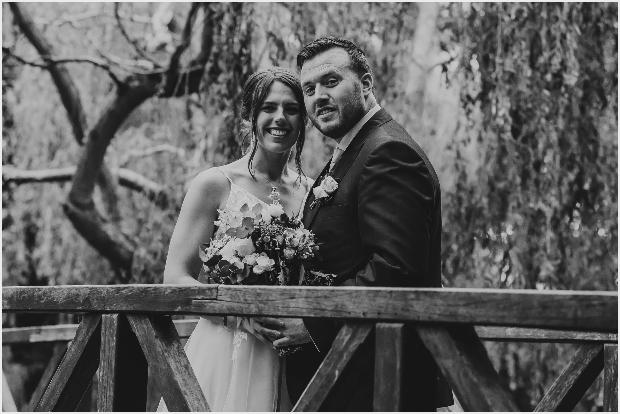 A beaming bride and groom look at the camera during their couples photoshoot at The Grosvenor Pulford Hotel and Spa.  Image captured by Helena Jayne Photography a wedding photographer based in Chester