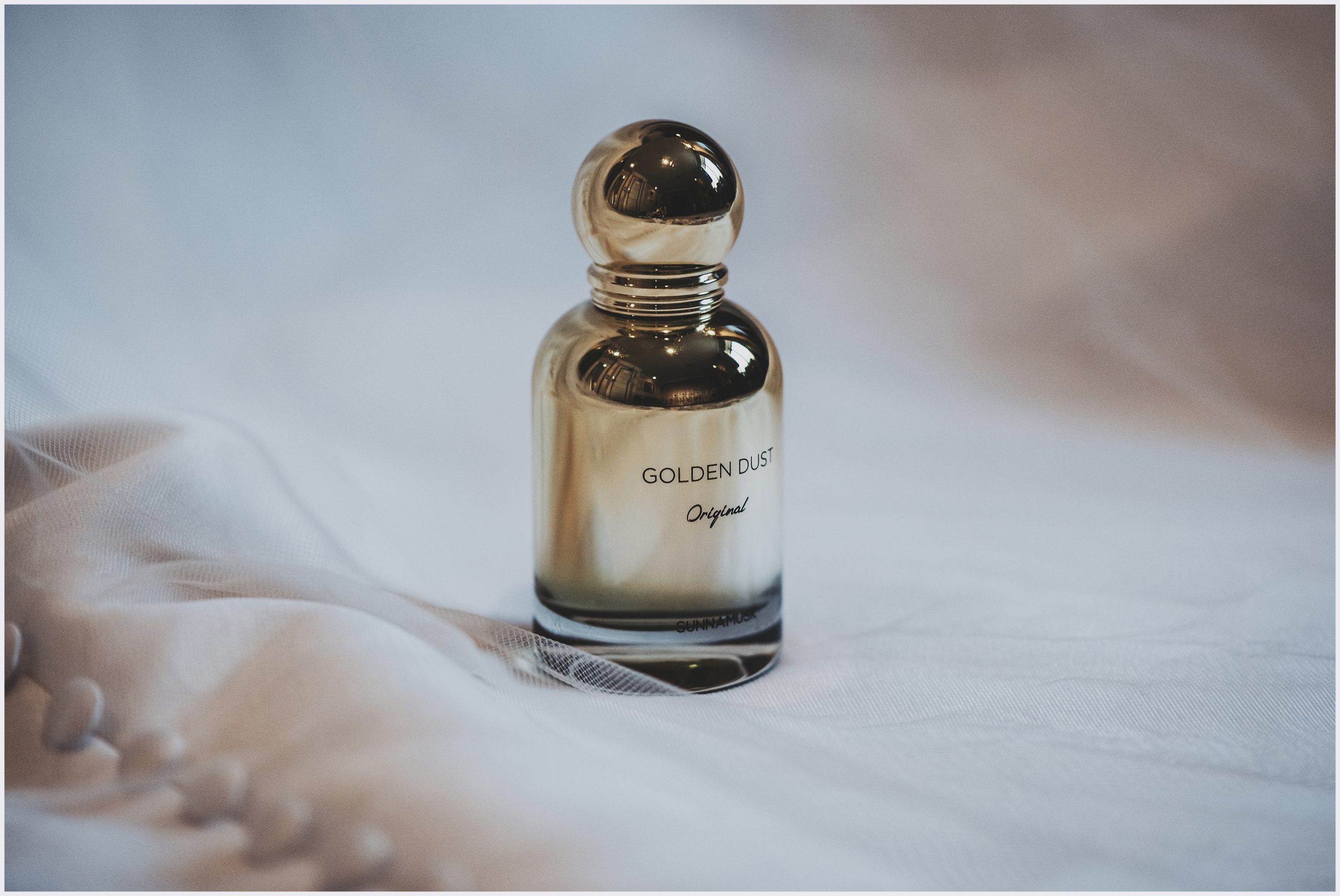 A bottle of Golden Dust perfume.  An image taken as part of wedding details at The Grosvenor Pulford Hotel and Spa