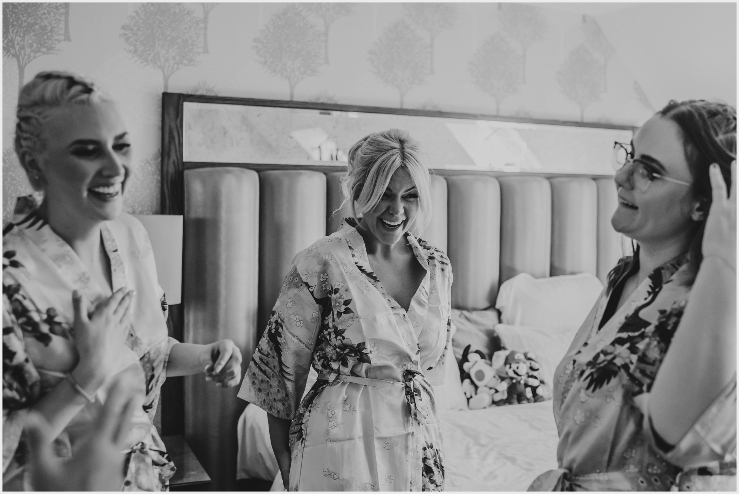 A bride and her bridesamids laughing and joking on the morning of the wedding.  Image captured by Helena Jayne Photography, a wedding photographer based in Cheshire