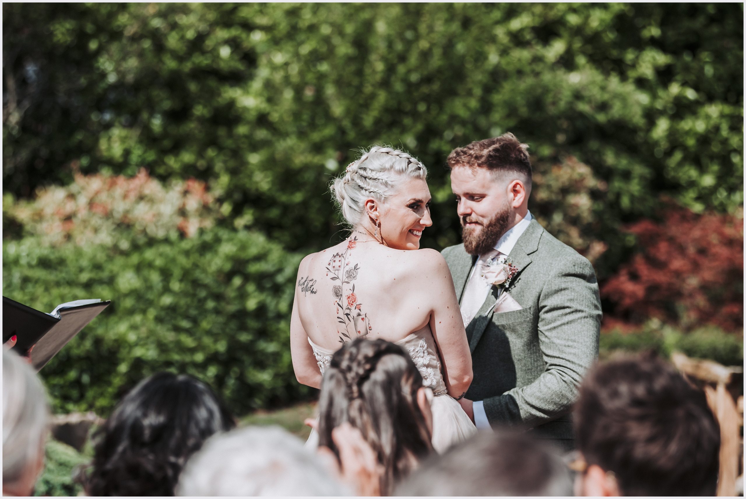 A bride turning round to smile at her guests during her outdoor wedding ceremony at The Grosvenor Pulford Hotel and Spa.  Image captured by helena Jayne Photorgaphy, Grosvenor Pulford wedding photographer
