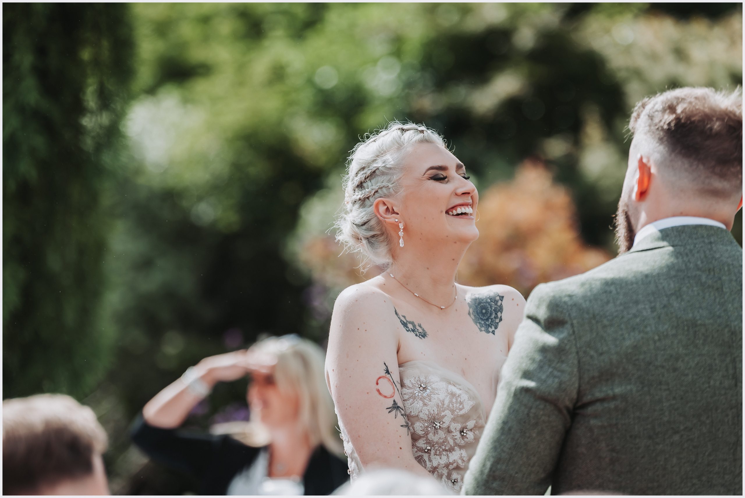 A beautiful bride throws her head back laughing during her outdoor ceremony at The Grosvenor Pulford Hotel and Spa.  North Wales based wedding photographer