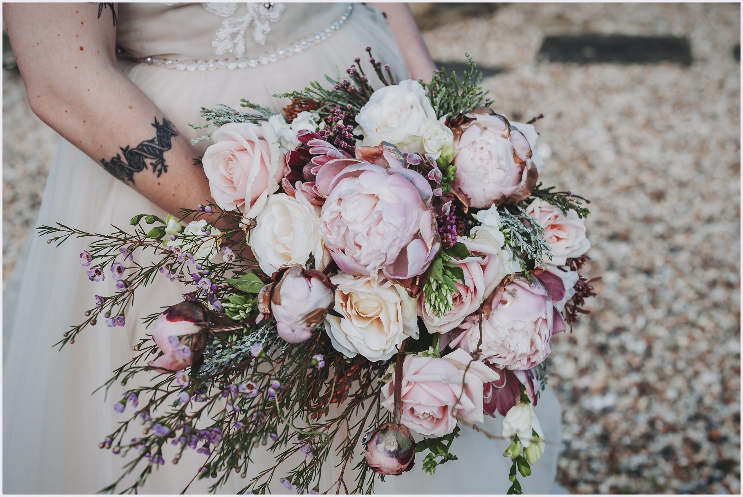 A stunning bouquet of flowers is held by a bride.  